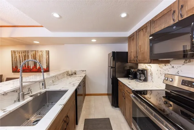 a kitchen with stainless steel appliances granite countertop a sink stove and refrigerator