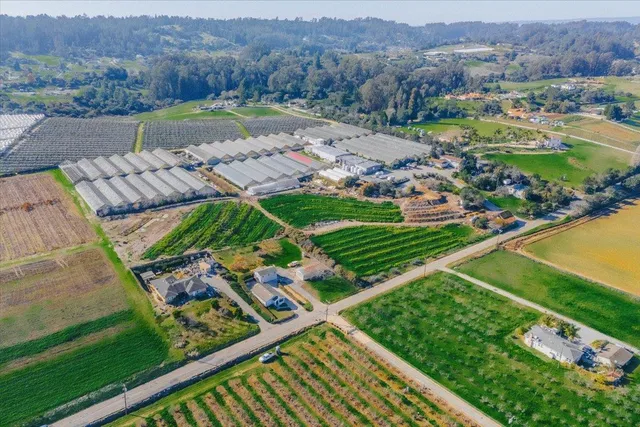 an aerial view of residential houses with outdoor space and street view