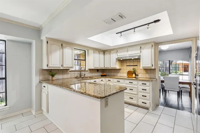 a kitchen with white cabinets and white appliances