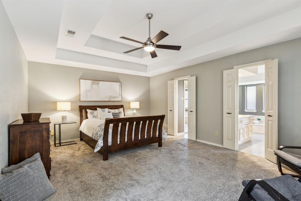 4130 High Star Lane Dallas, TX 75287 - Photo 19 of 38 a spacious bedroom with a bed and a chandelier