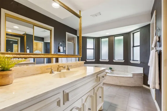 a bathroom with a tub sink and mirror