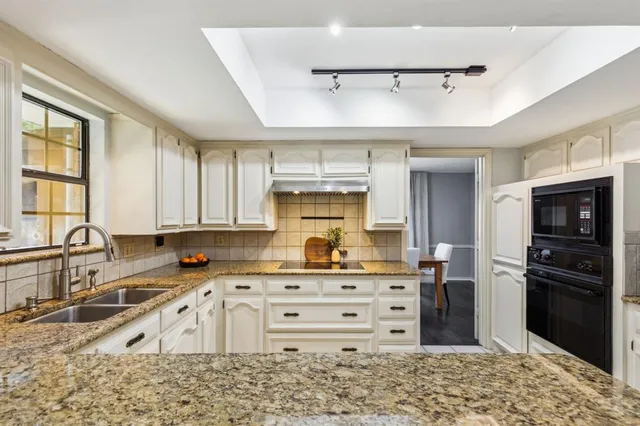 a kitchen with kitchen island granite countertop a stove cabinets and refrigerator