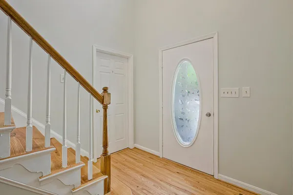 a view of entryway bedroom and hall with wooden floor