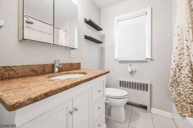 a bathroom with a granite countertop sink a toilet and a mirror