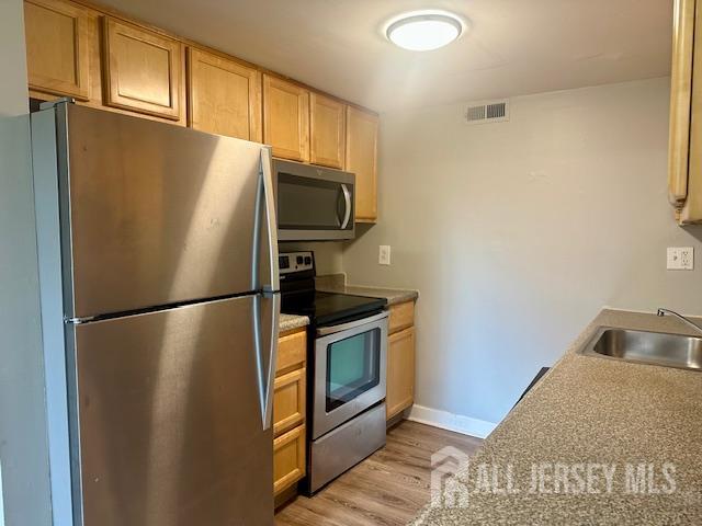 356 Ridge Road, Unit J12 Dayton, NJ 08810 - Photo 27 of 42 a metallic refrigerator freezer sitting in a kitchen