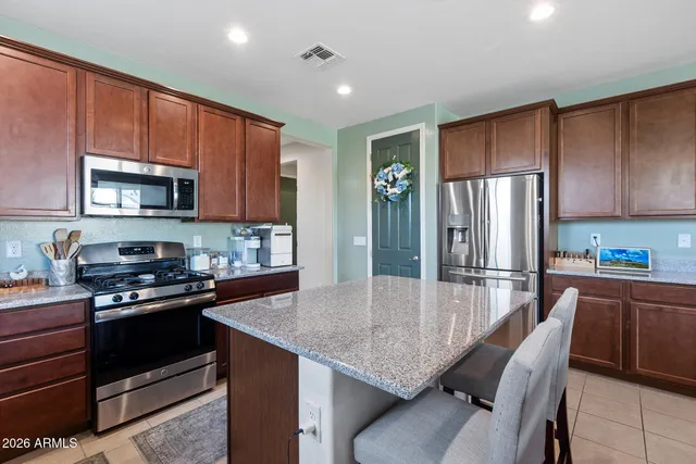 a kitchen with refrigerator and chairs