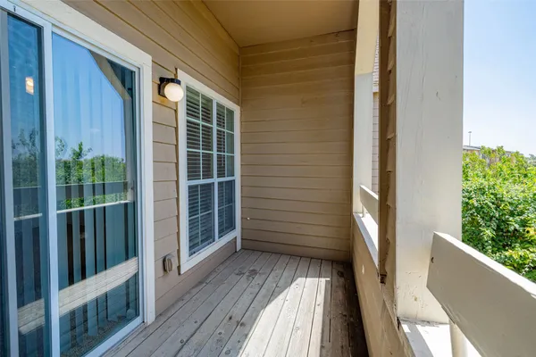 a view of a balcony with wooden floor and fence