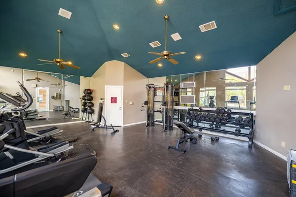 a room with lots of gym equipment and a large window