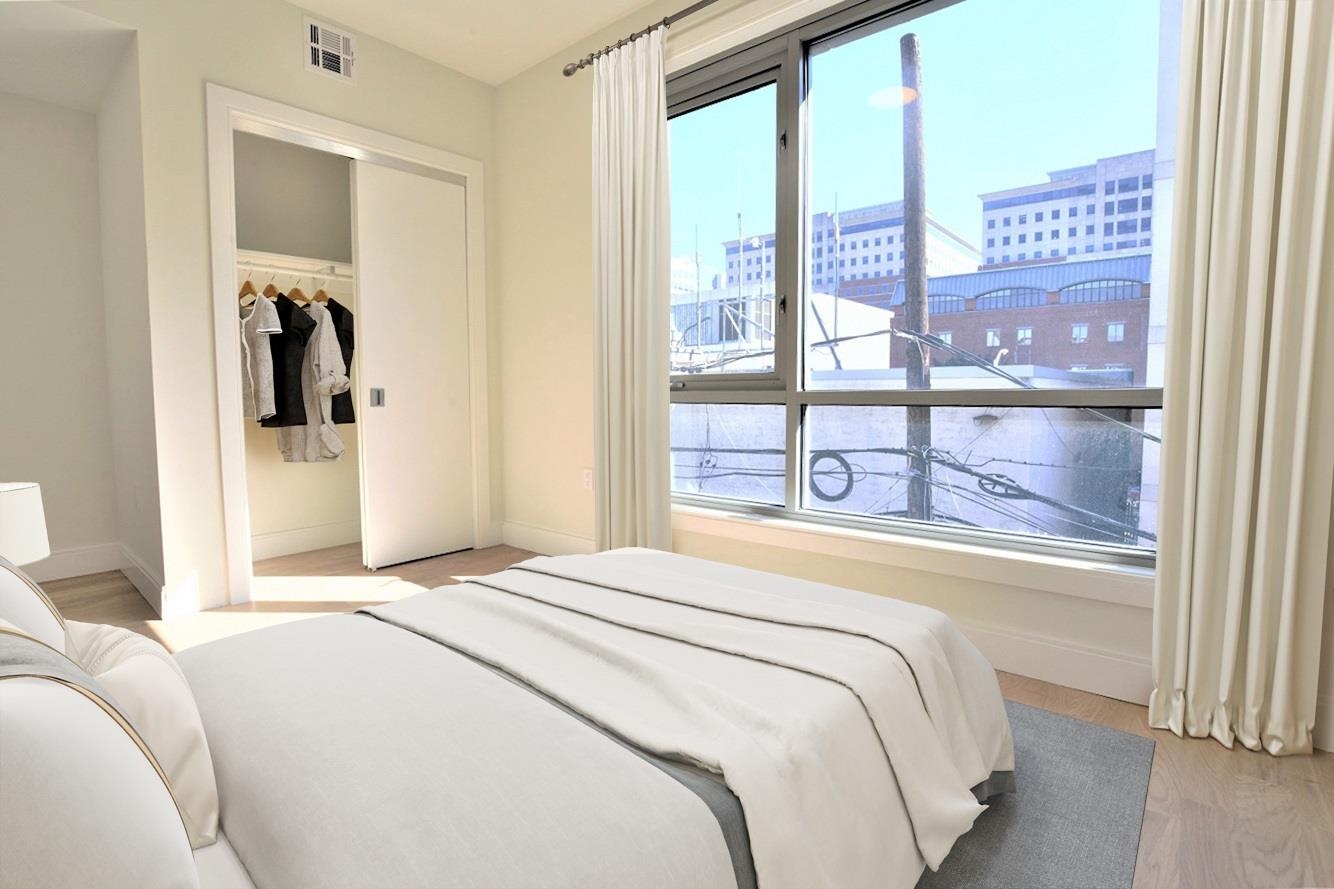110 Court Street, Unit 2 Hoboken, NJ 07030 - Photo 7 of 14 a bedroom with a bed and a large window