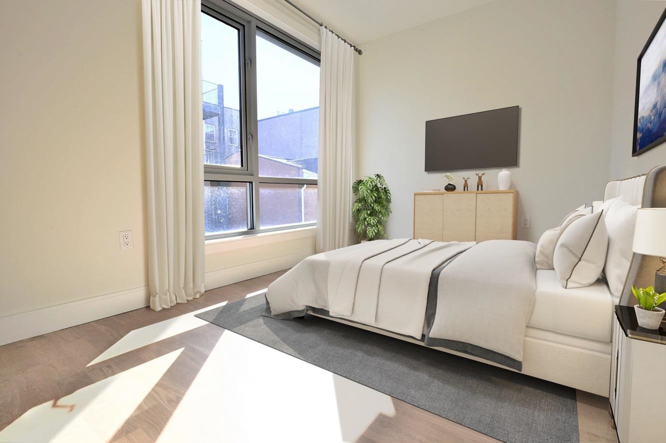 110 Court Street, Unit 2 Hoboken, NJ 07030 - Photo 8 of 14 a bedroom with a bed tv and a window