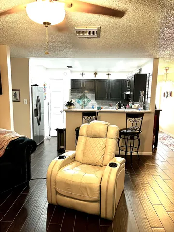 a living room with furniture a flat screen tv and kitchen view