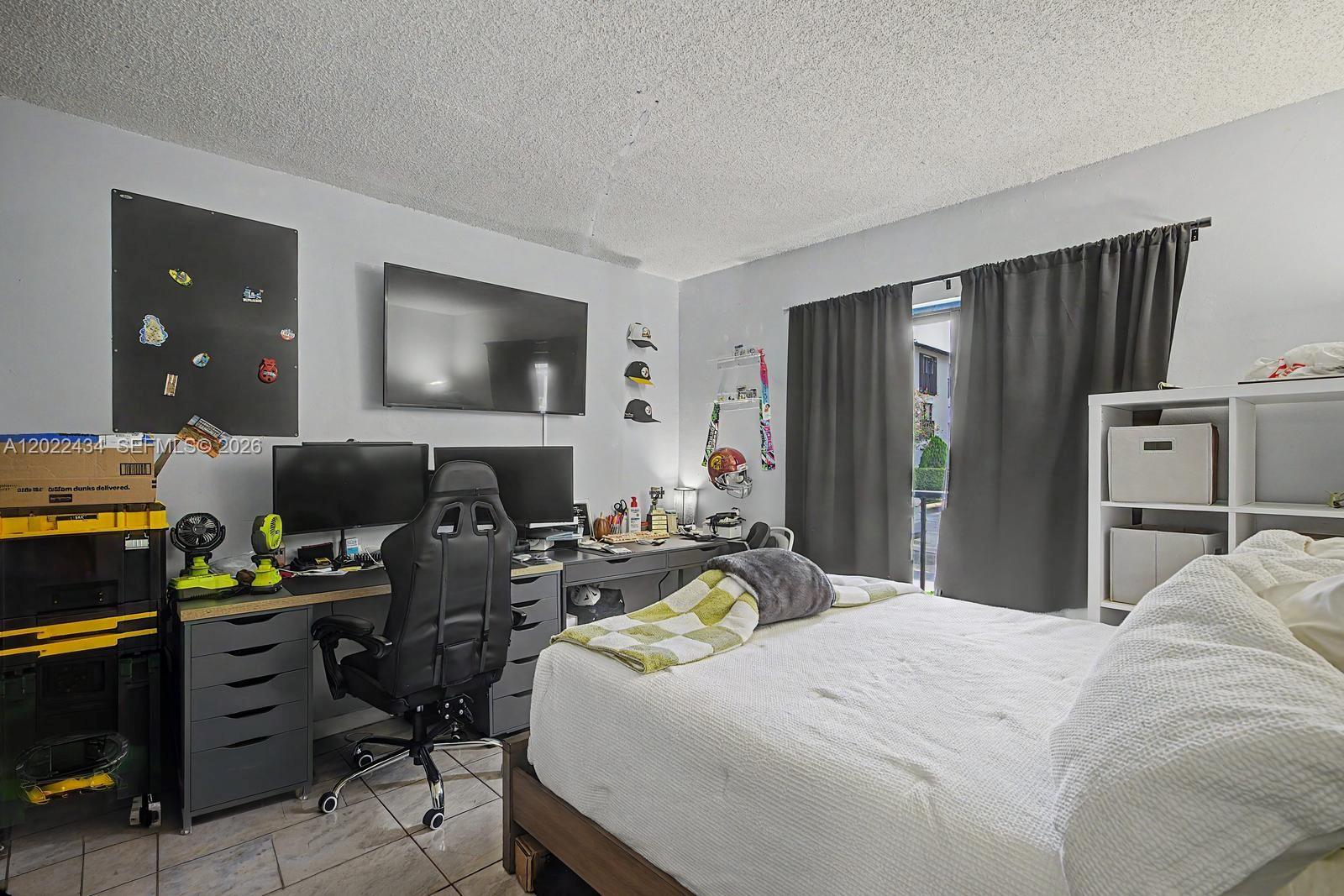 13045 Southwest 68th Street, Unit 111 Miami, FL 33183 - Photo 11 of 15 a bedroom with a bed and a flat screen tv