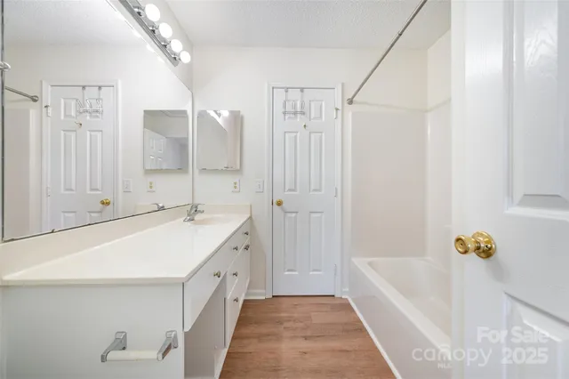 a bathroom with a tub sink and mirror