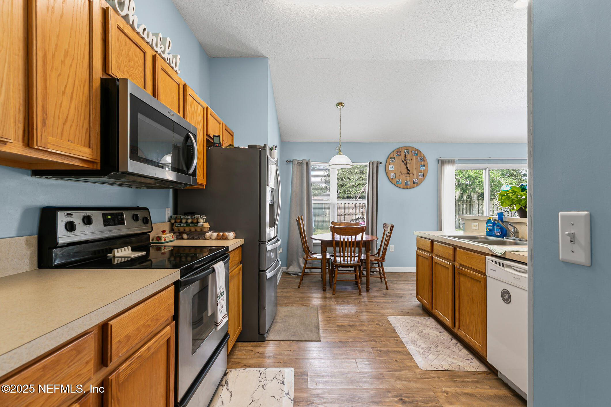 1725 South Summer Ridge Court St. Augustine, FL 32092 - Photo 13 of 46 a kitchen with stainless steel appliances granite countertop a stove top oven a sink a dining table and chairs with wooden floor