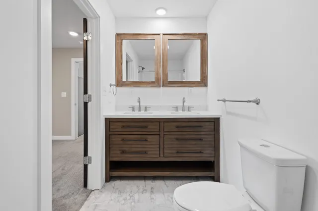 a bathroom with a sink vanity mirror and toilet