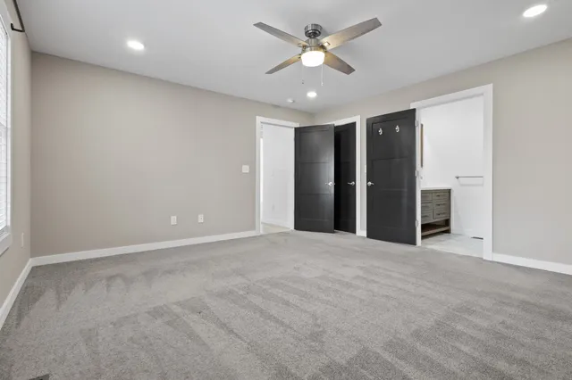 an empty room with closet and windows