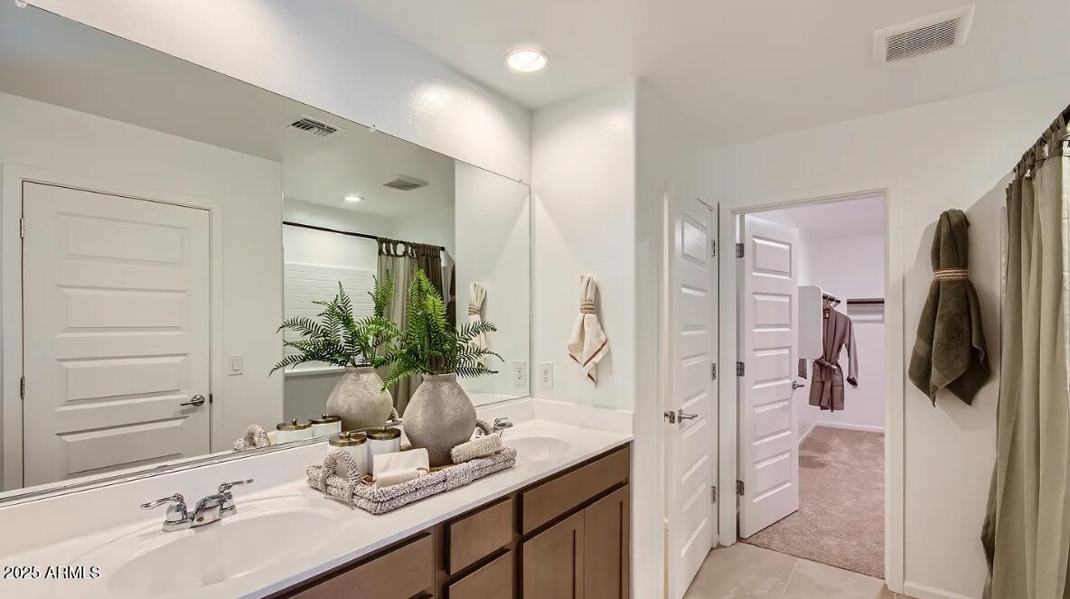 9517 West Cheery Lynn Road Phoenix, AZ 85392 - Photo 10 of 27 a bathroom with a granite countertop sink a mirror and shower
