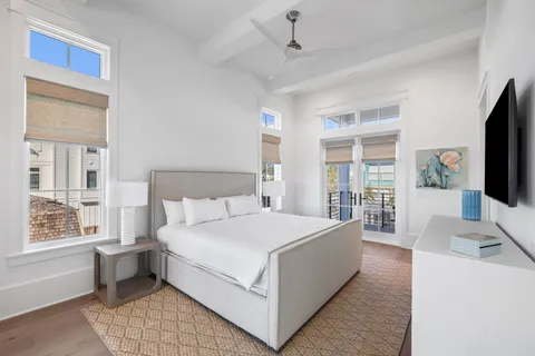 a large white bed sitting in a bedroom next to a window