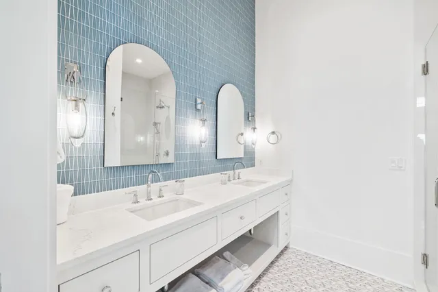 a en suite bathroom with a double vanity sink and a mirror