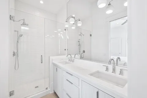 a kitchen with stainless steel appliances granite countertop a stove a sink dishwasher and white cabinets with wooden floor