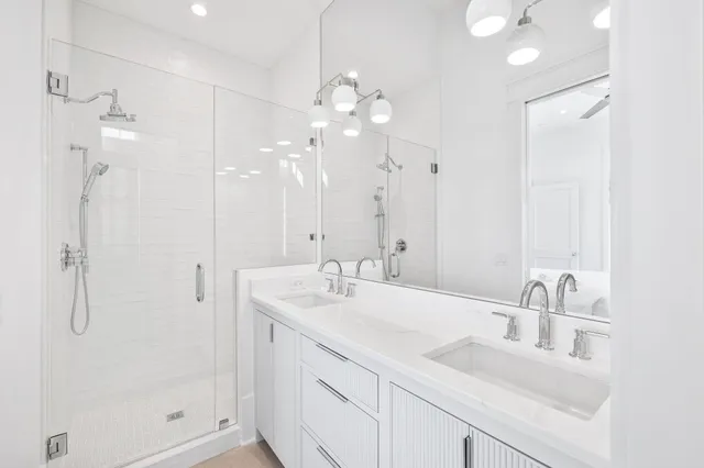 a kitchen with stainless steel appliances granite countertop a stove a sink dishwasher and white cabinets with wooden floor