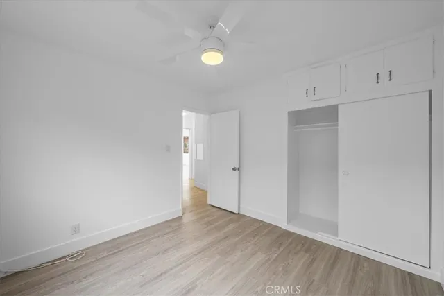 a view of an empty room with wooden floor and windows