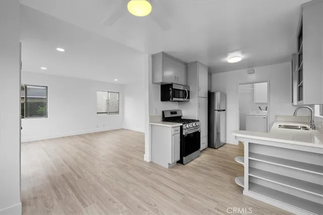 a kitchen with a refrigerator and a stove top oven