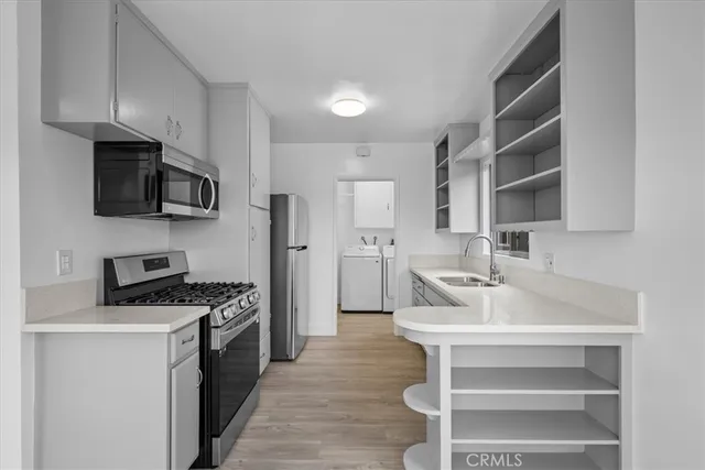a kitchen with a sink cabinets and stainless steel appliances