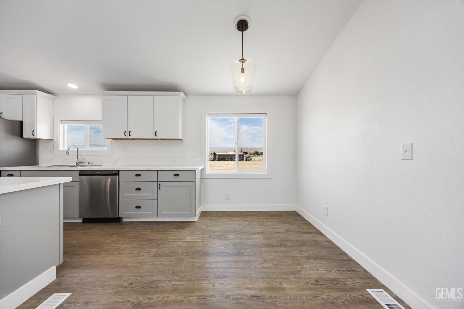 Undisclosed Address Taft, CA 93268 - Photo 19 of 40 a kitchen with granite countertop a stove a sink and white cabinets