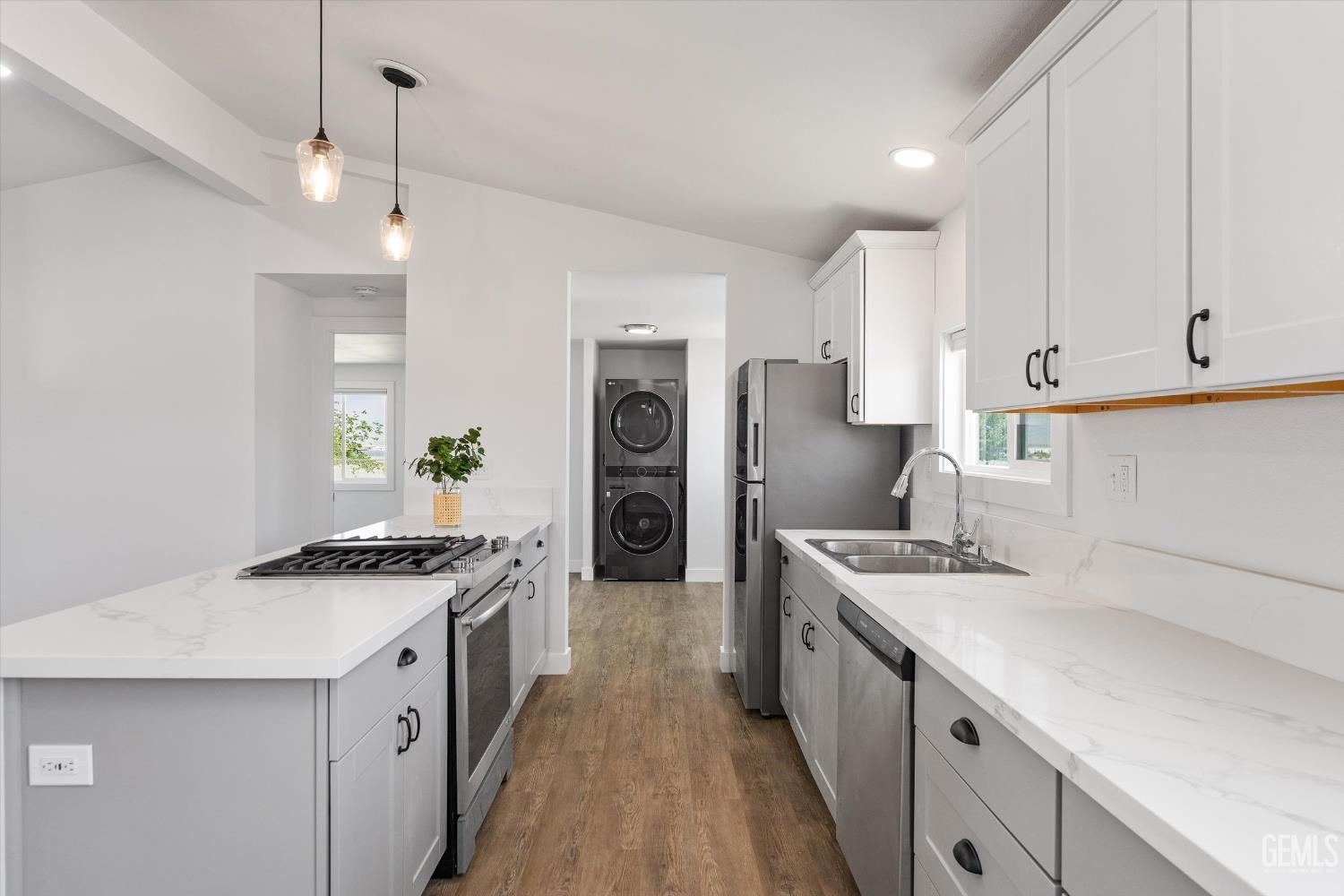 Undisclosed Address Taft, CA 93268 - Photo 24 of 40 a kitchen with stainless steel appliances a stove a sink a refrigerator white cabinets and wooden floor