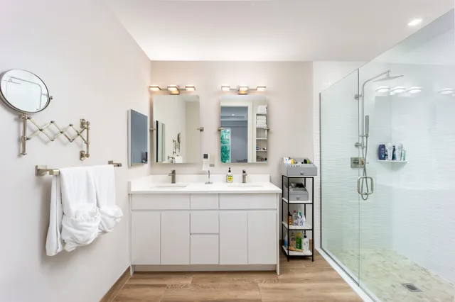 a bathroom with a double vanity sink mirror and shower