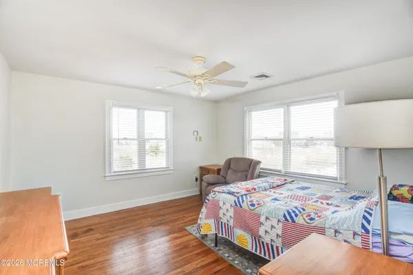 a view of an empty room with stairs & wooden floor