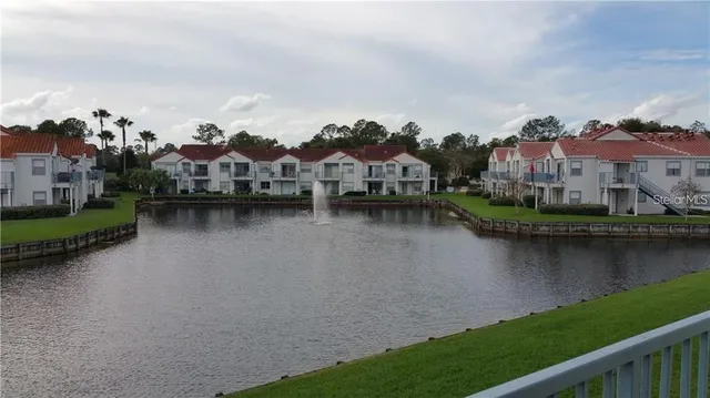 an aerial view of residential houses with outdoor space and lake view