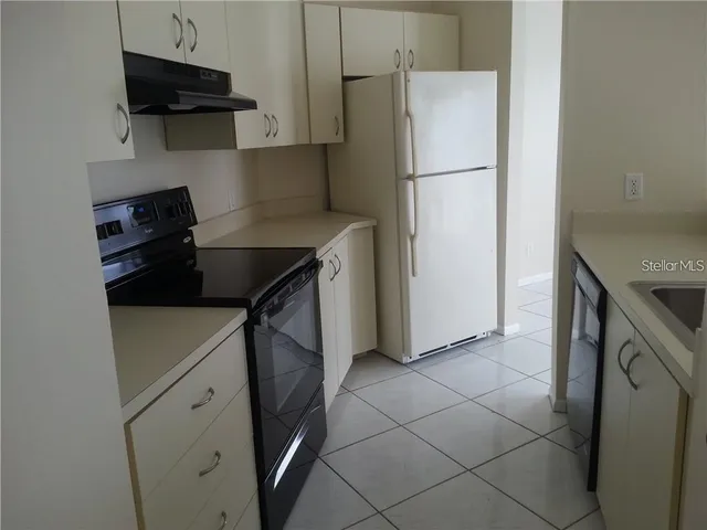 a kitchen with a refrigerator and a stove