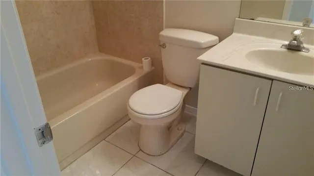 a white toilet sitting next to a bathroom sink and vanity