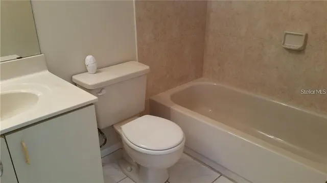 a white toilet sitting next to a bath tub