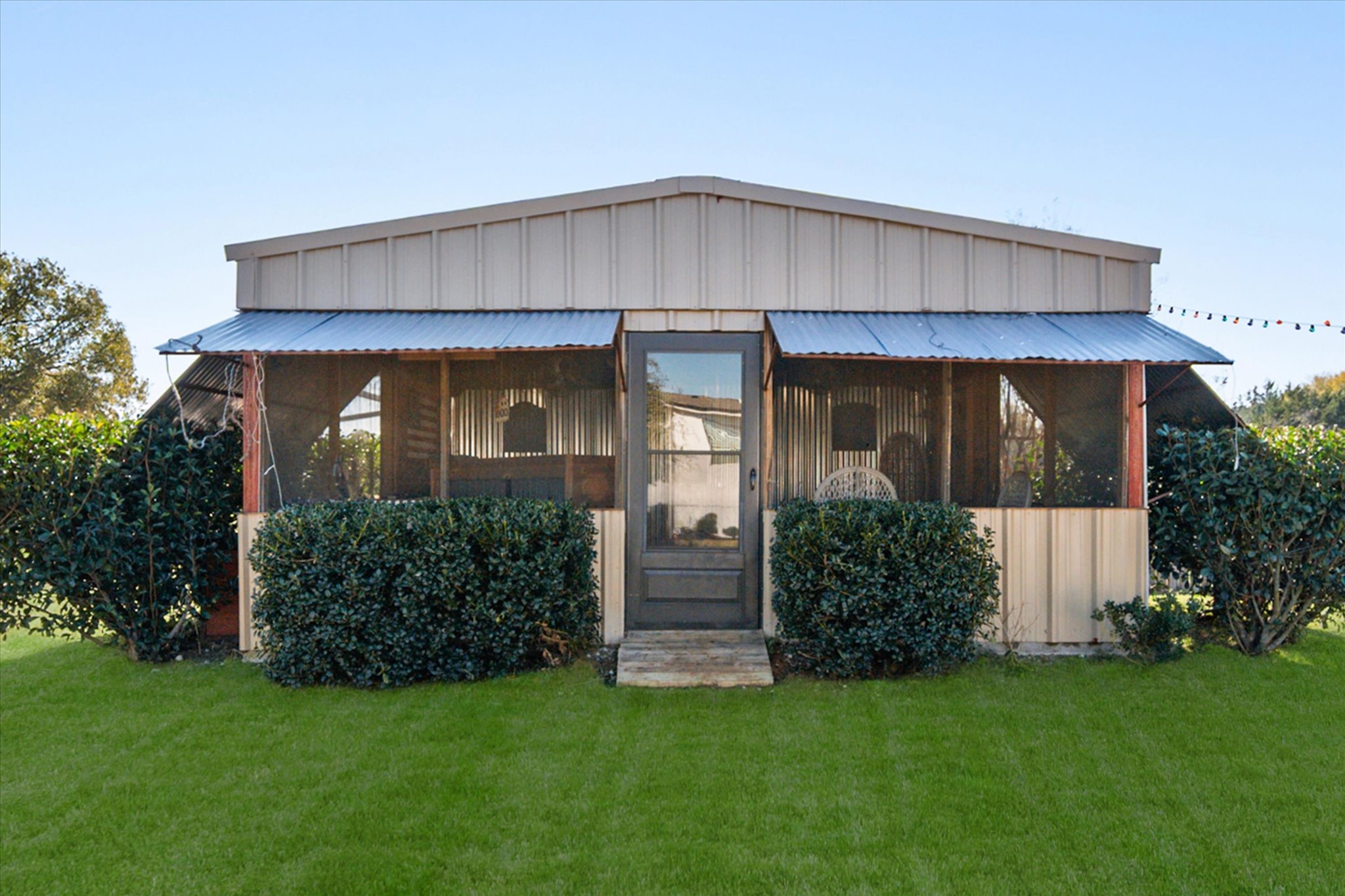 16857 Fm 639 Road East Purdon, TX 76679 - Photo 4 of 38 View of front of property featuring a sunroom, a front yard, and a metal roof