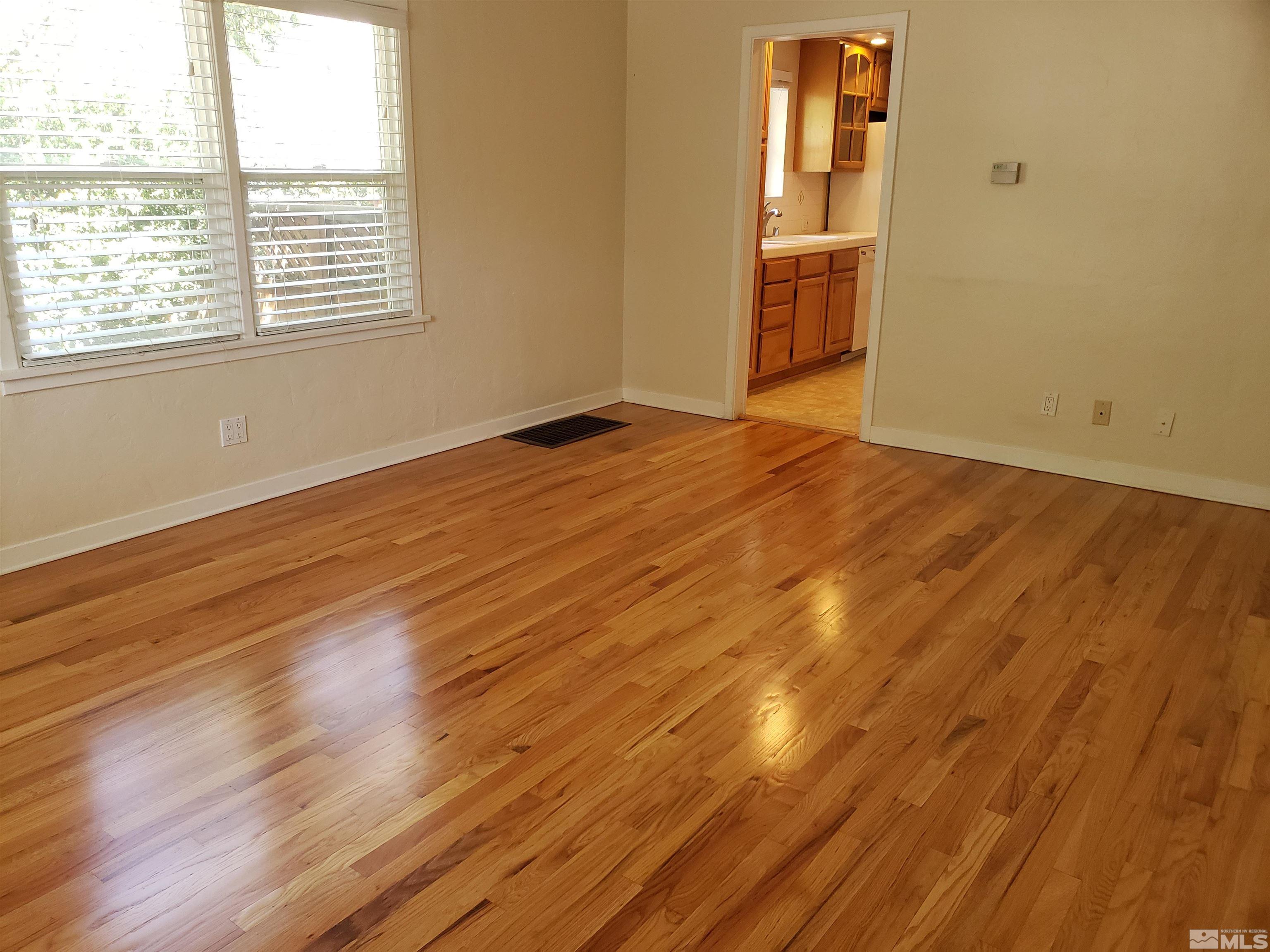 649 West Arroyo Street Reno, NV 89509 - Photo 3 of 40 an empty room with wooden floor and windows
