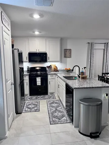 a kitchen with stainless steel appliances granite countertop a stove a sink a refrigerator and a refrigerator