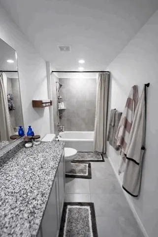 a bedroom with a bed lamp and a potted plant