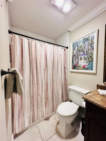 a bathroom with a toilet a sink and a shower curtain