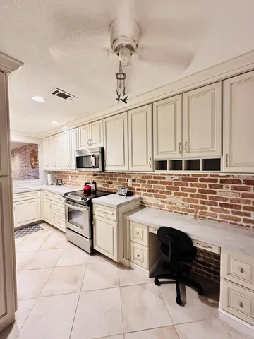 a kitchen with stainless steel appliances kitchen island granite countertop a stove sink and cabinets