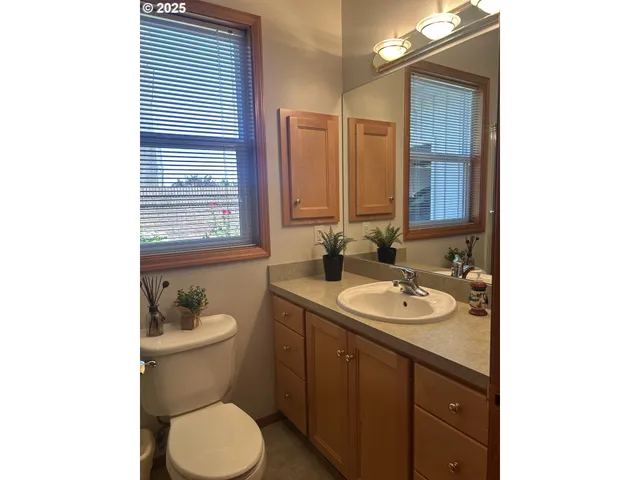 a bathroom with a granite countertop toilet sink and mirror