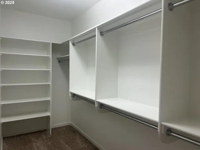 a view of walk in closet with empty racks