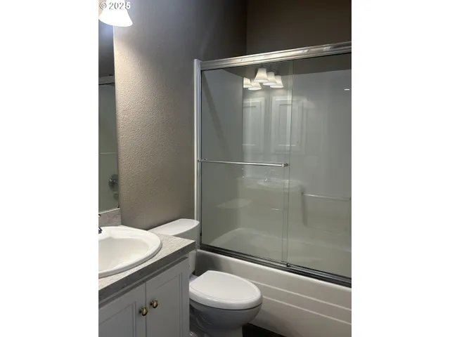 a bathroom with a shower a toilet and a sink