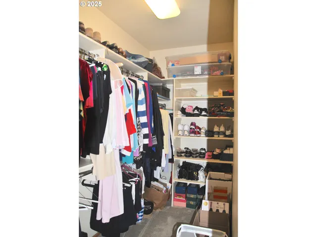 a view of walk in closet with clothes and shoes