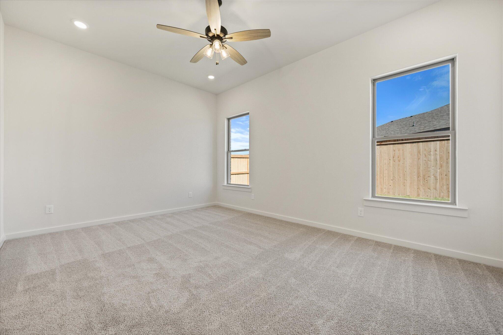 7003 53rd Street Lubbock, TX 79407 - Photo 14 of 25 an empty room with windows and fan