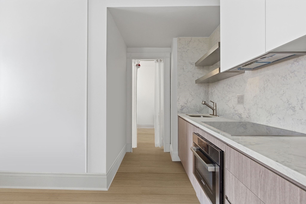 21 Beacon Street, Unit 11L Boston, MA 02108 - Photo 5 of 23 a kitchen with a sink stove and cabinets