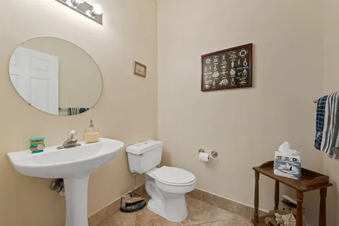 a bathroom with a toilet a sink and a mirror