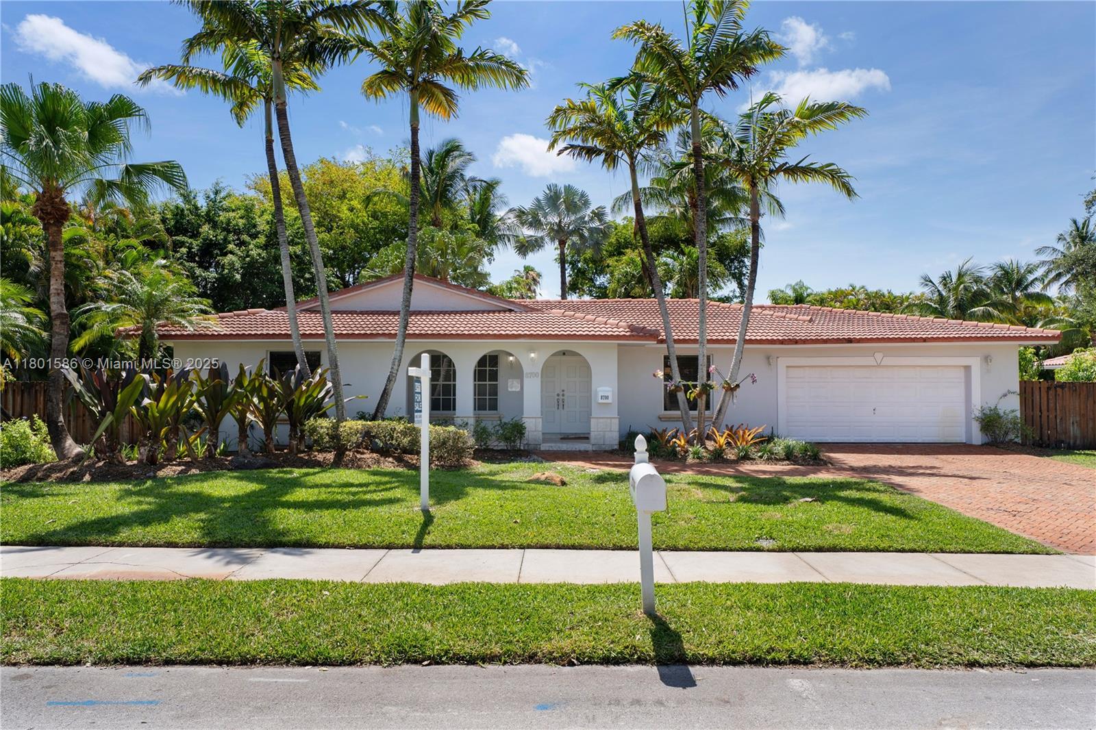 8700 Southwest 64th Avenue Pinecrest, FL 33156 - Photo 1 of 11 a front view of house with yard and green space